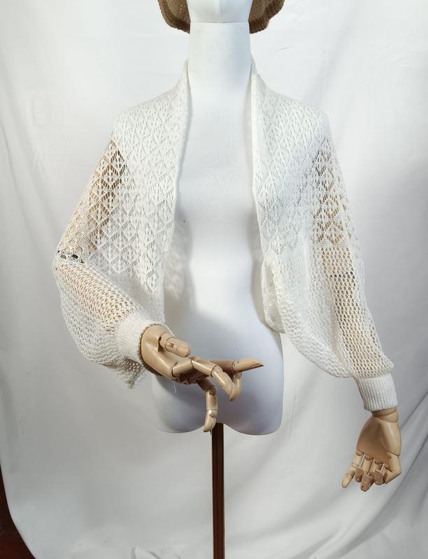 Bolero shrug corto in pizzo bianco a maglia aperta con maniche a palloncino lunghe e polsini a coste su manichino — accessorio moda donna elegante e versatile in tessuto traforato leggero. - B2B wholesale inquiry welcome